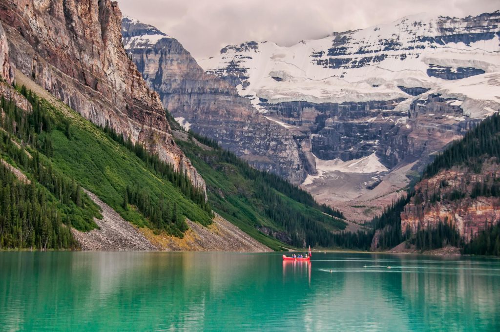 Red boat in the lake near mountain